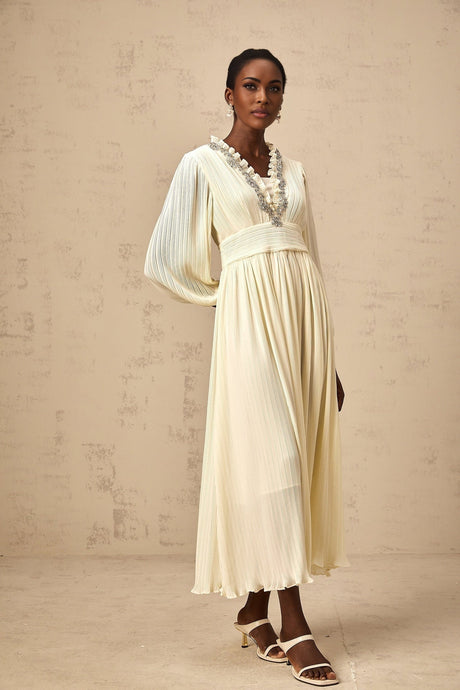 A white pleated midi dress with crystal trim details along the neckline and waist named Yana