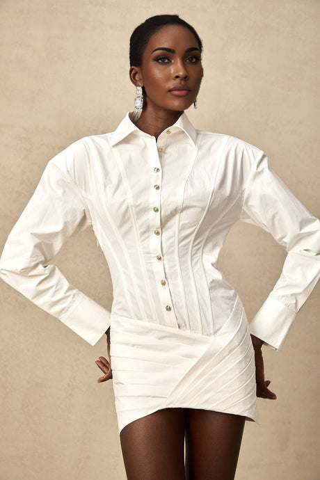 A white pleated mini shirt dress with a fitted waist