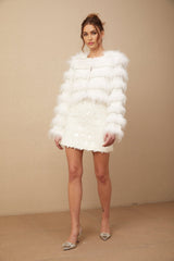 A white puffy fur jacket adorned with crystal embellishments featuring a Margherita design pattern