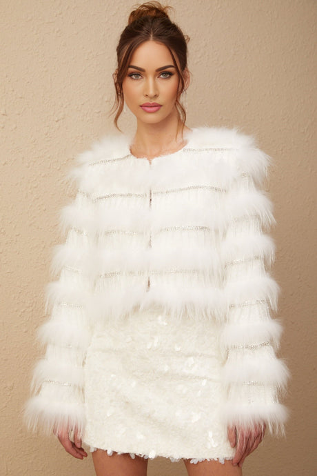 A white puffy fur jacket adorned with crystal embellishments in a floral pattern resembling a margherita design