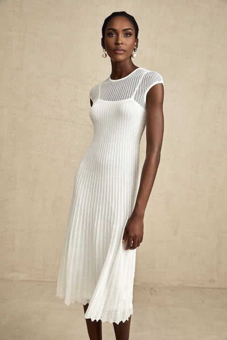 A white semisheer midi dress with scalloped hem details and delicate lace patterns named Liane