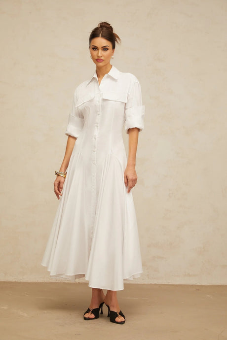 A white shirt dress with a front slit and shirred detailing featuring a collar and buttonup design