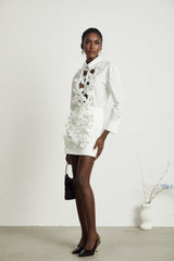 A white shirt with a floral pattern featuring cut out details and the name Rosalie