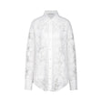 A white shirt with delicate lace embroidery and strategic cut out details featuring long sleeves and a collar