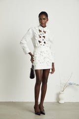 A white shirt with floral cutout patterns featuring a delicate Rosalie design
