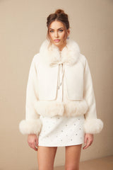 A white short coat made of suede with fur padding and lining featuring a cozy design suitable for cold weather