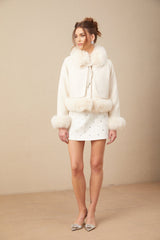 A white short coat made of suede with fur padding and trim featuring a cozy design and luxurious appearance