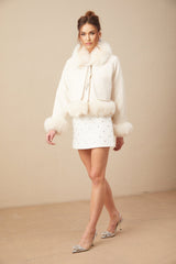 A white short coat made of suede with fur padding featuring a padded design and a cozy appearance suitable for cold weather