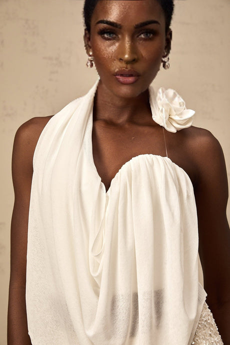 A white sleeveless halterneck top with floral appliqué details called Maeva