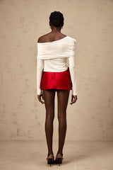 A white sleeveless jersey top with an asymmetric design featuring a twisted detail on one side