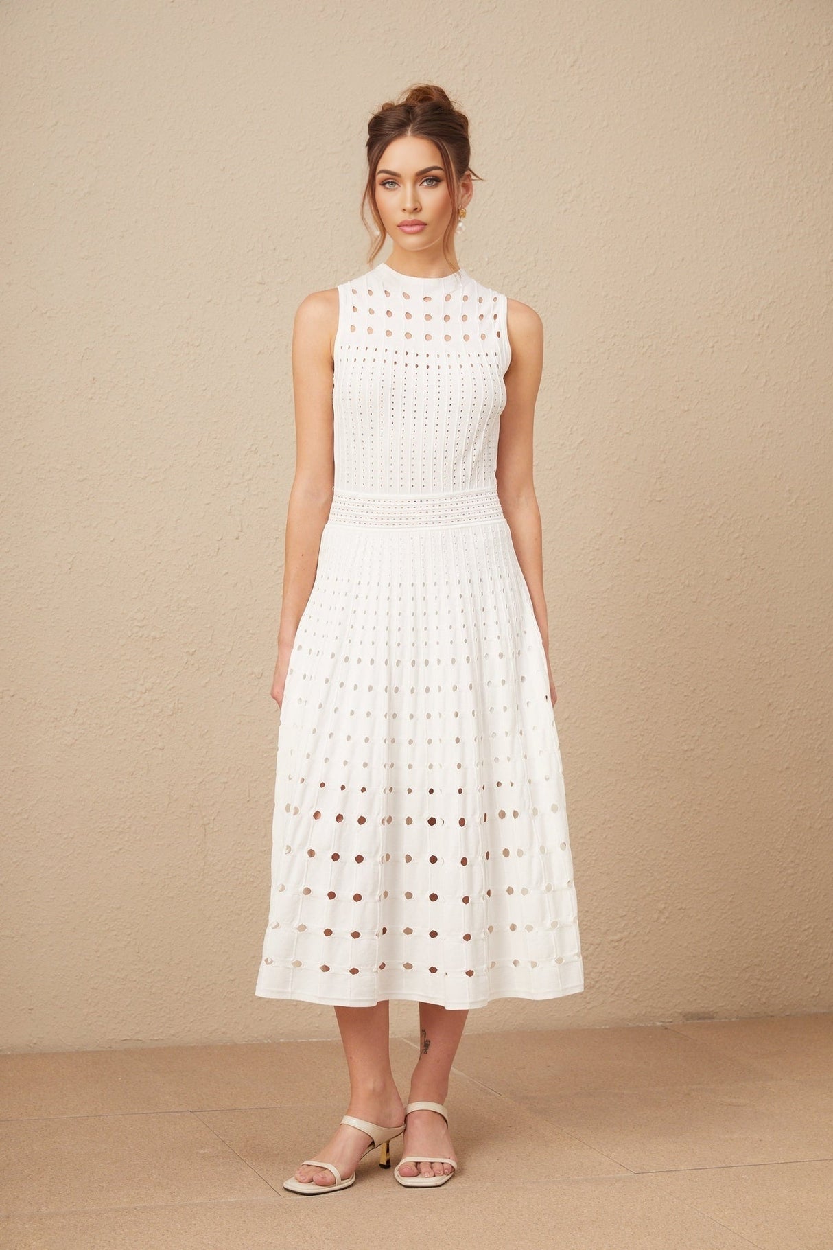 A white sleeveless knitted midi dress with cutout details featuring a fitted silhouette and a high neckline named Charlotte