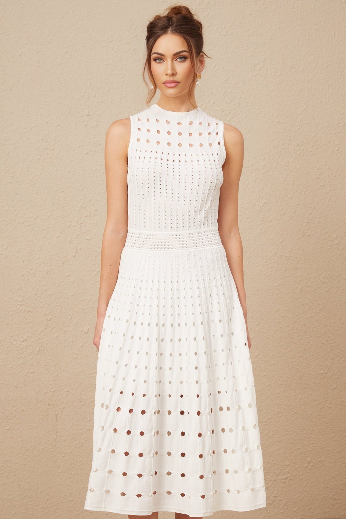 A white sleeveless knitted midi dress with cutout details modeled on a female figure against a plain background
