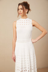A white sleeveless midi dress with cutout details and a knitted fabric featuring a fitted silhouette and a high neckline
