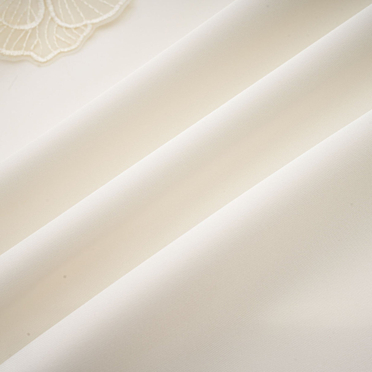 A white sleeveless midi dress with floral applique details named Emilie