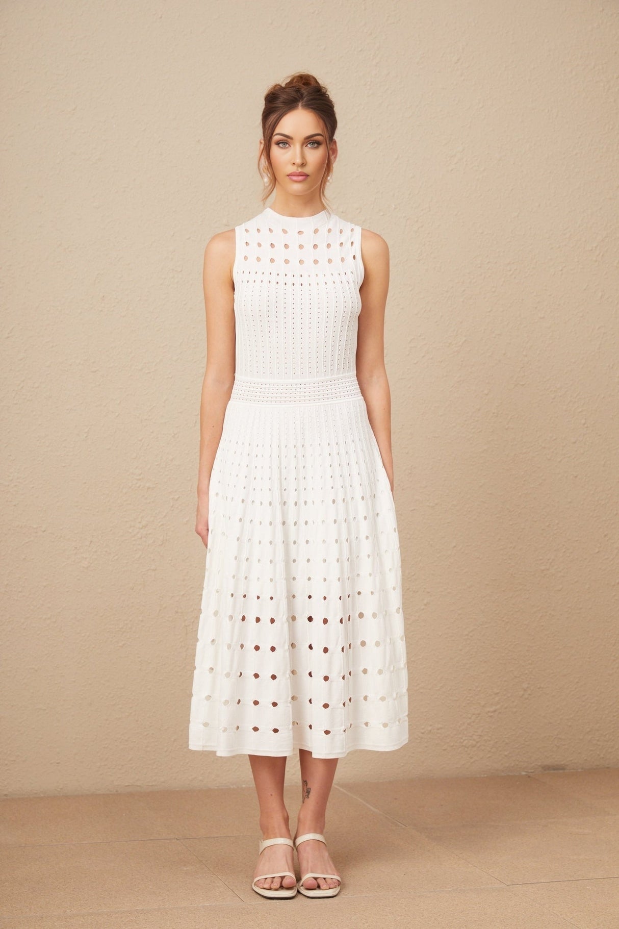 A white sleeveless midi dress with knitted fabric and cutout details
