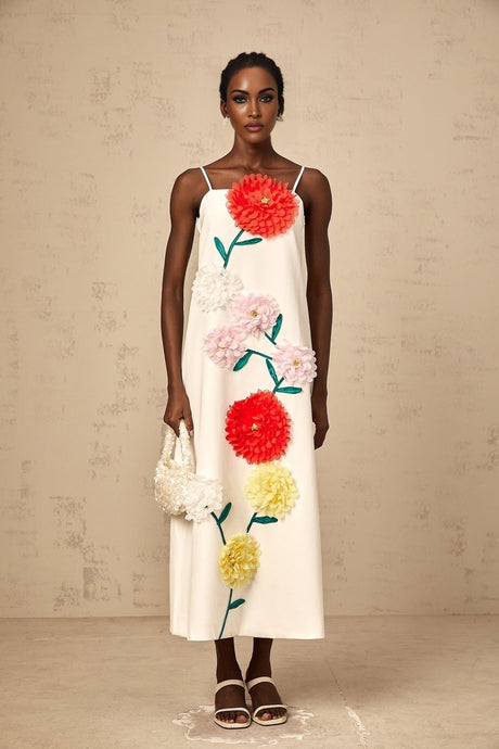 A white sleeveless midi dress with three dimensional petal details covering the bodice