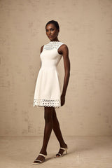 A white sleeveless mini dress with knitted fabric and cutout details featuring a short length and fitted silhouette
