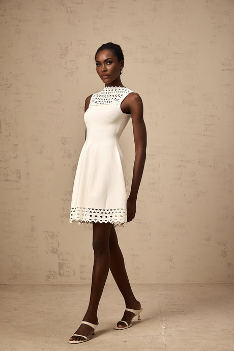 A white sleeveless mini dress with knitted fabric and cutout details featuring a short length and fitted silhouette