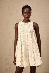 A white sleeveless mini dress with wavy detailing named Axelle on a plain background