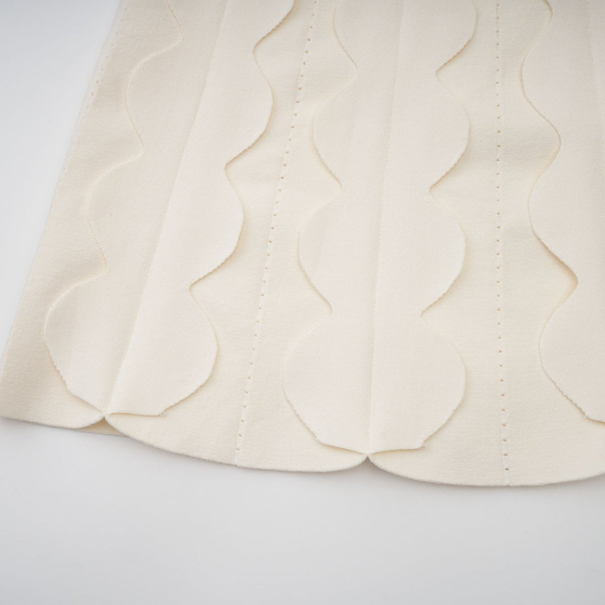 A white sleeveless mini dress with wavy details called Axelle