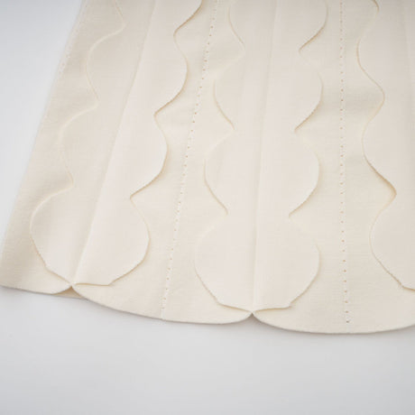 A white sleeveless mini dress with wavy details called Axelle