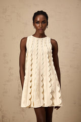 A white sleeveless mini dress with wavy details on a female model named Axelle