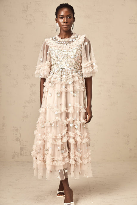 A white tiered midi dress with floral embroidery and ruffled details shown on a model against a plain background