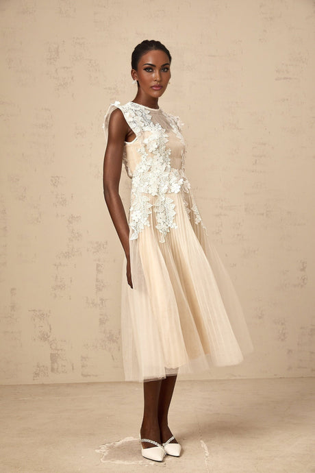 A white tulle midi dress with delicate floral appliques scattered across the bodice and skirt creating a romantic and ethereal look