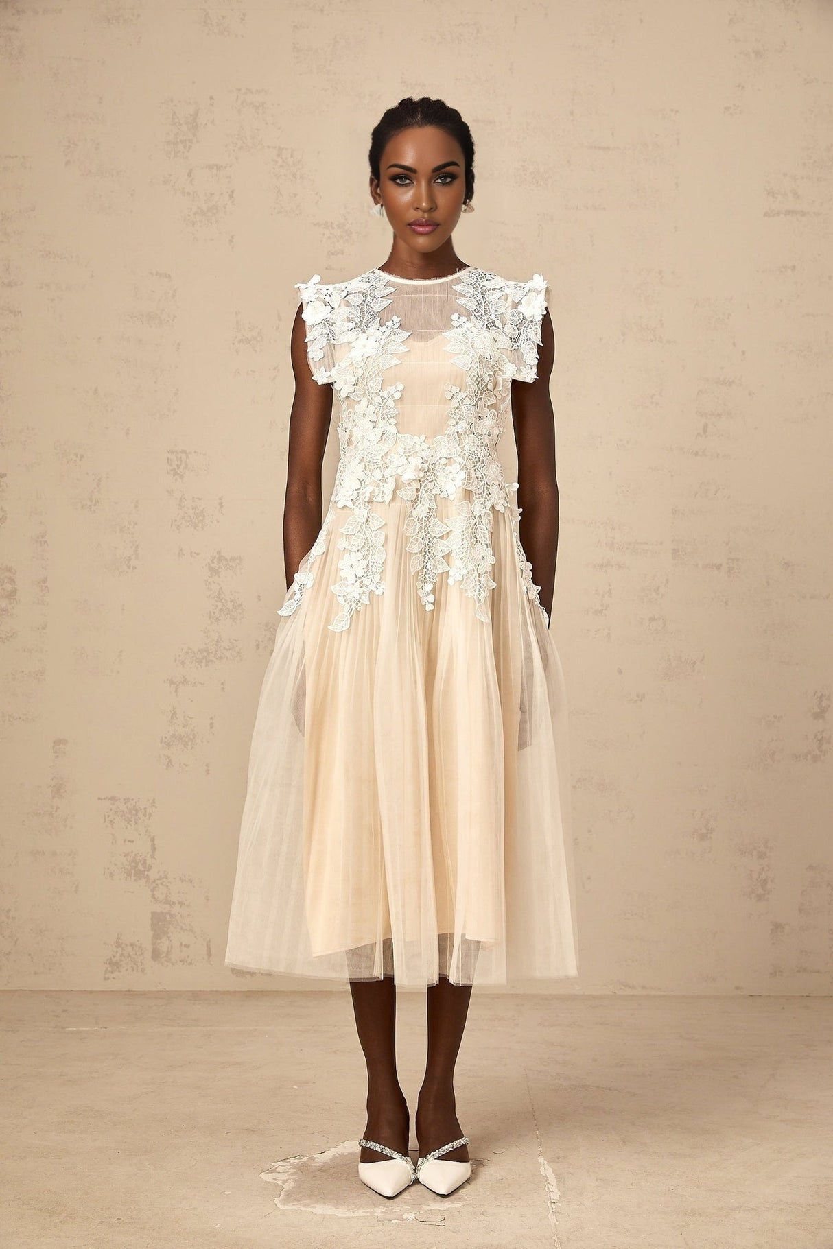 A white tulle midi dress with delicate flower appliques scattered across the bodice and skirt featuring a fitted waist and flowing silhouette
