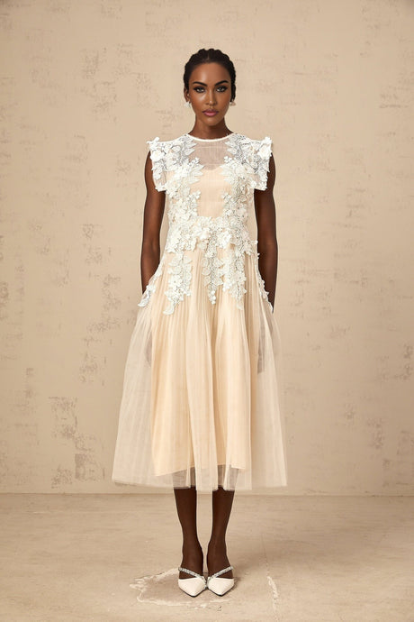 A white tulle midi dress with delicate flower appliques scattered across the bodice and skirt featuring a fitted waist and flowing silhouette