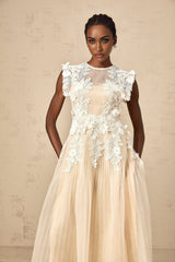 A white tulle midi dress with delicate flower appliques scattered across the bodice and skirt featuring a fitted waist and flowy silhouette