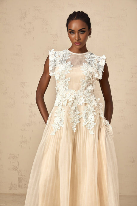 A white tulle midi dress with delicate flower appliques scattered across the bodice and skirt featuring a fitted waist and flowy silhouette