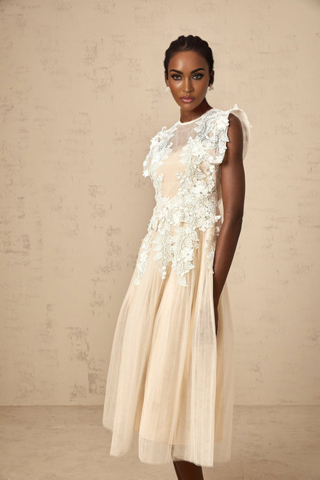 A white tulle midi dress with delicate flower appliques scattered throughout featuring a fitted bodice and flowy skirt
