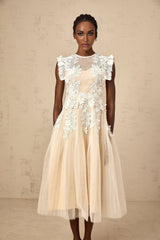A white tulle midi dress with floral appliques scattered across the bodice and skirt featuring a fitted waist and delicate straps