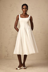 A white tulle midi dress with godet inserts featuring a fitted bodice and flared skirt