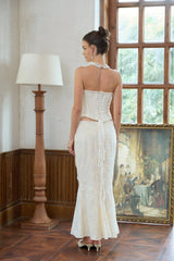 A white twopiece outfit consisting of an embroidered top and matching skirt set named Margot