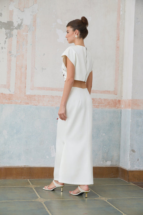 A white twopiece outfit featuring a sleeveless top and skirt set adorned with shell embellishments named Delphine