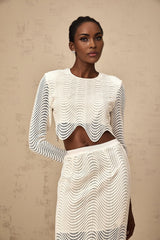 A white twopiece outfit featuring a wavy woven texture consisting of a top and matching skirt called Constance