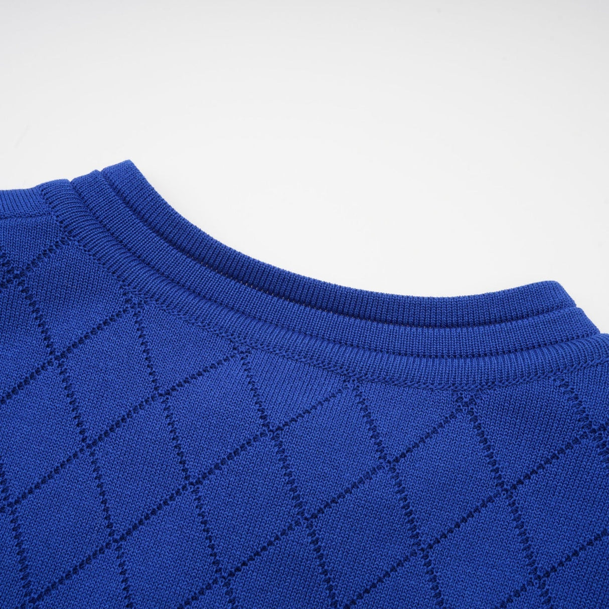 A woman wearing a blue knitted matching set consisting of a long sleeve top with button details and a fitted skirt