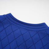 A woman wearing a blue knitted matching set consisting of a long sleeve top with button details and a fitted skirt