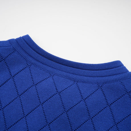 A woman wearing a blue knitted matching set consisting of a long sleeve top with button details and a fitted skirt