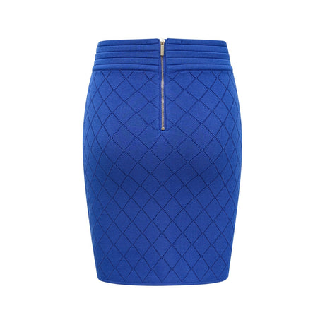 A woman wearing a blue knitted matching set consisting of a top with button details and a skirt