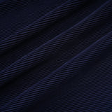 A woman wearing a blue patterned cape and matching skirt set Debbie model The cape is creased and flows over the shoulders The skirt is fitted and falls below the knee Both pieces feature a repeating print pattern in shades of blue