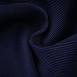 A woman wearing a blue patterned cape and matching skirt set The cape has a creased texture and the skirt features the same print The outfit is called Debbie and has a coordinated look