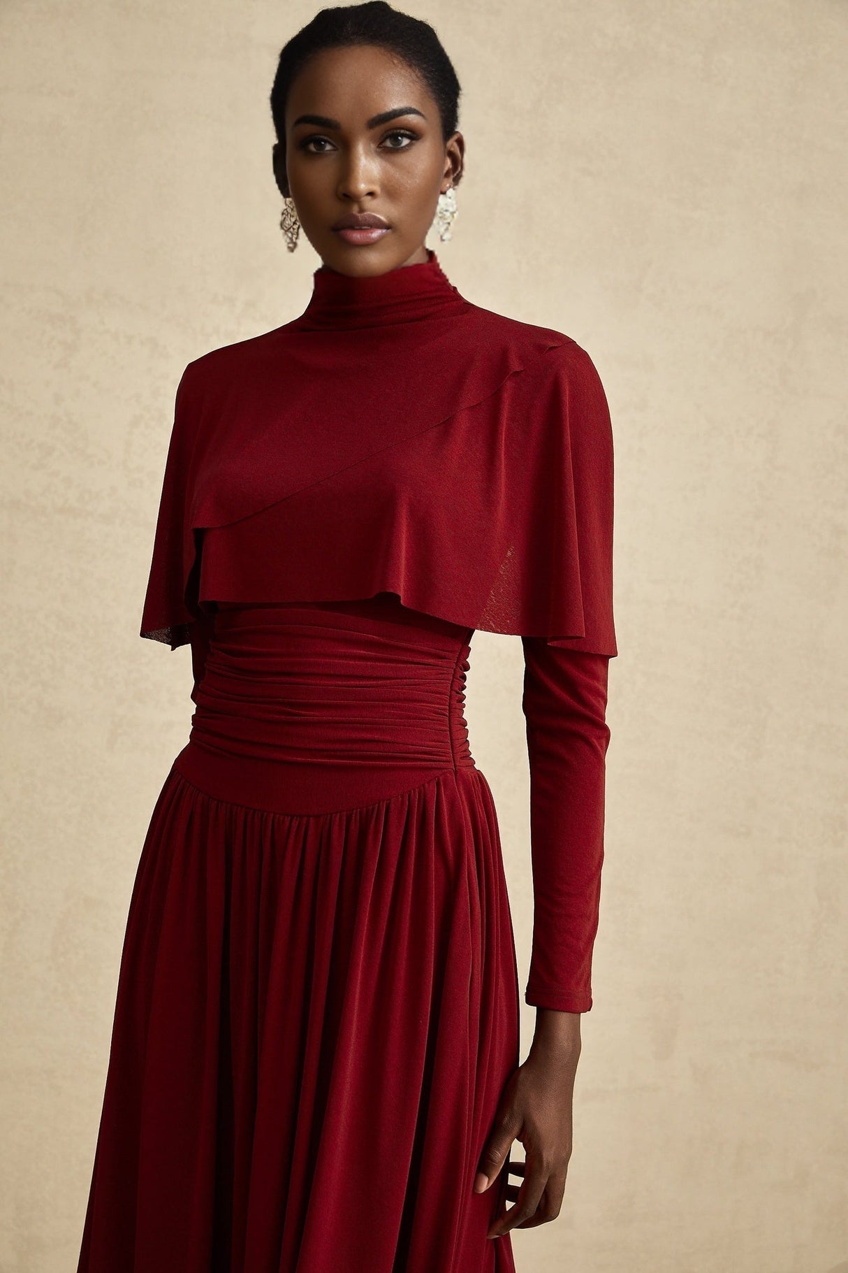 A woman wearing a bright red midi dress with ruched detailing and a flap design on the bodice