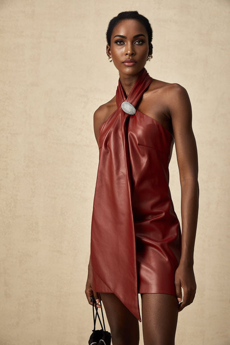 A woman wearing a bright red mini dress made of sheepskin with a halter neckline the dress has a form fitting silhouette and ends above the knees