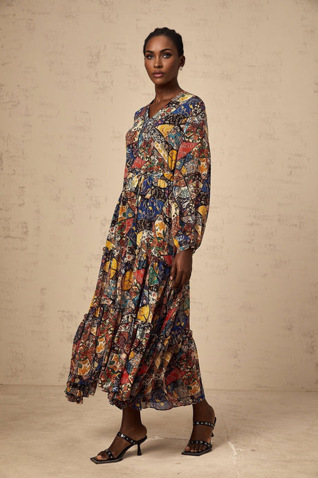 A woman wearing a brown bohemian style midi dress with shirring details and a flowing silhouette