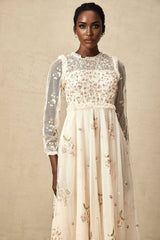 A woman wearing a Celine midi dress made of tulle fabric with delicate floral embroidery details throughout the bodice and skirt