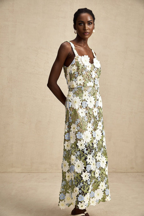 A woman wearing a floral embroidered midi dress with hollow carved details standing in a casual pose