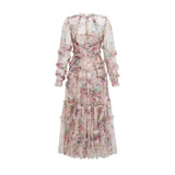 A woman wearing a floral patterned midi dress with ruffled details and a tulle skirt standing in a relaxed pose